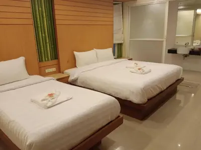 two beds in a hotel room with towels on them at Patong Terrace Hotel in Patong Beach