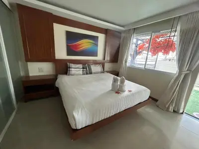 a bedroom with a large white bed with a window at Patong Terrace Hotel in Patong Beach