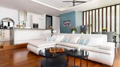 a living room with a white couch and a table at The Natai Villas - By AP Natai in Phang-nga