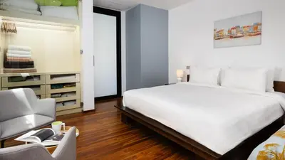 a bedroom with a large white bed and a chair at The Natai Villas - By AP Natai in Phang-nga