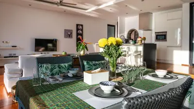 a dining room with a table with a green table cloth at The Natai Villas - By AP Natai in Phang-nga