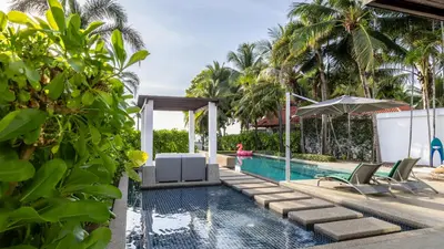 a pool at a villa with palm trees at The Natai Villas - By AP Natai in Phang-nga