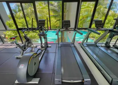 a gym with treadmills and a swimming pool at Bangtao Beach Apartments in Bang Tao Beach
