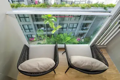 two chairs in front of a window with plants at Bangtao Beach Apartments in Bang Tao Beach