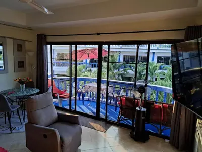 a living room with a view of a balcony at Homely with pool near the beach in Kamala Phuket in Kamala Beach