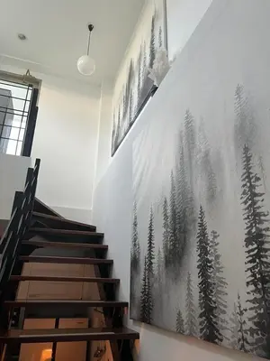 a staircase with a painting of trees on the wall at The Regent Kamala Penthouse with private pool in Kamala Beach