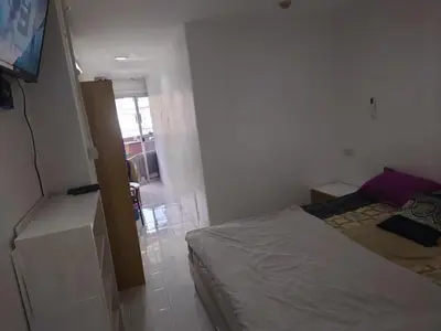 a small bedroom with a bed and a television at Phuket Palace apartment with 2 separate rooms in Patong Beach