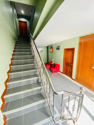 a staircase in a house with a red couch at BT hotel Kata Beach in Kata Beach