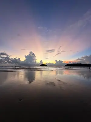 a sunset on a beach with the ocean at BT hotel Kata Beach in Kata Beach