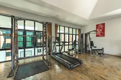 a gym with two treadmills and two tread machines at Coco Retreat Phuket Resort and Spa - SHA Plus in Chalong