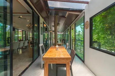 a dining room with a wooden table and chairs at Coco Retreat Phuket Resort and Spa - SHA Plus in Chalong