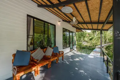 a porch with benches and windows on a house at Coco Retreat Phuket Resort and Spa - SHA Plus in Chalong