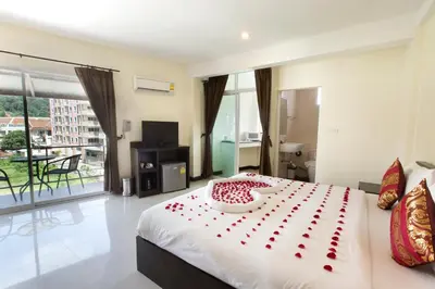 a bedroom with a bed with red rose petals on it at The Elegant Patong in Patong Beach