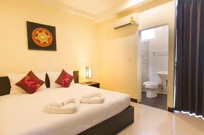 a bedroom with a bed with two towels on it at The Elegant Patong in Patong Beach