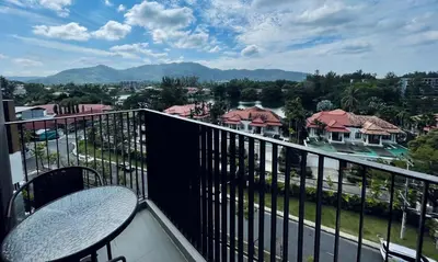 a balcony with two tables and a view of a city at Laguna Skypark in Phuket Town