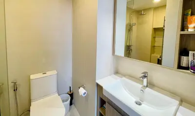 a bathroom with a sink and a toilet and a mirror at Laguna Skypark in Phuket Town