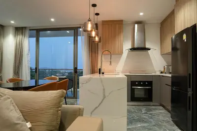 a kitchen and living room with a counter top at Elite Atoll Serviced Apartments Phuket in Rawai Beach