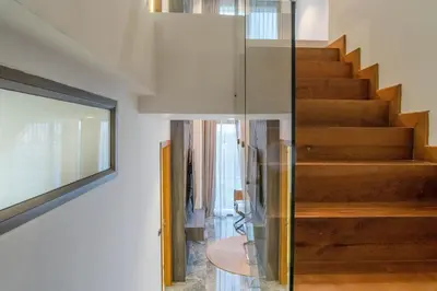 a glass staircase in a house with wooden floors at Elite Atoll Serviced Apartments Phuket in Rawai Beach