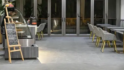 a row of tables and chairs in front of a restaurant at Elite Atoll Serviced Apartments Phuket in Rawai Beach
