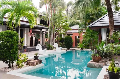 a swimming pool in front of a house with white swans at Villa Banyak Luxury 4Br villa with nice terrace in Rawai Beach