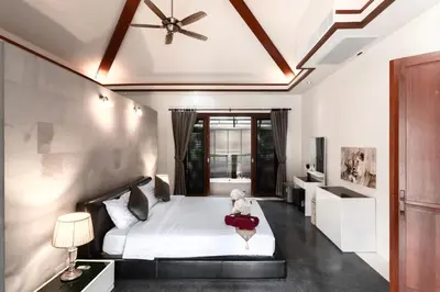 a bedroom with a bed and a ceiling fan at Villa Banyak Luxury 4Br villa with nice terrace in Rawai Beach