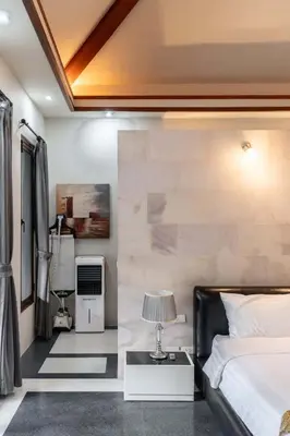 a bedroom with a bed and a table with a lamp at Villa Banyak Luxury 4Br villa with nice terrace in Rawai Beach