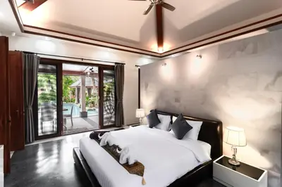 a bedroom with a large bed and a large window at Villa Banyak Luxury 4Br villa with nice terrace in Rawai Beach