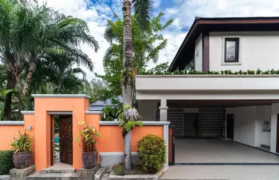 a house with orange paint and palm trees at Villa Banyak Luxury 4Br villa with nice terrace in Rawai Beach