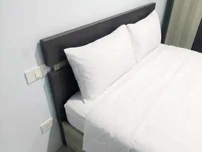 a close up of a bed with white sheets and pillows at Heimat Garden Homestay in Ban Lo Pa Ret