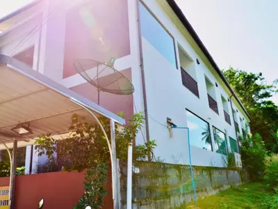 a building with a basketball hoop on the side of it at Heimat Garden Homestay in Ban Lo Pa Ret