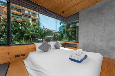 a bedroom with a large bed and a large window at Modern studio at Relife 2 min to Nai Harn beach in Rawai Beach