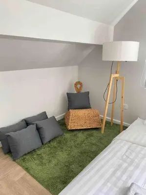 a room with a bed and a lamp and a couch at Naka Cozy House in Phuket City in Ban Rangeng
