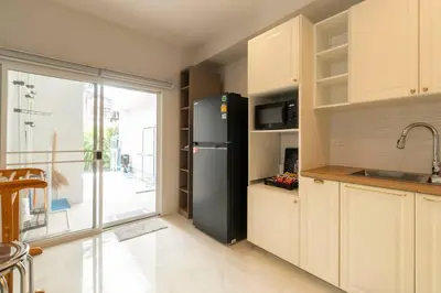 a kitchen with a black refrigerator and a balcony at Naka Cozy House in Phuket City in Ban Rangeng