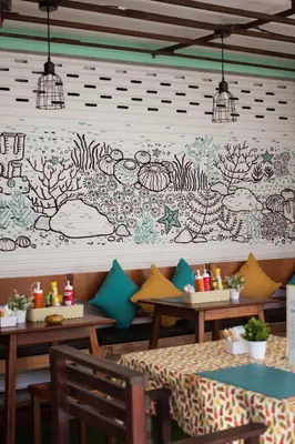 a restaurant with two tables and a mural on the wall at Kamala Beach Residence in Kamala Beach
