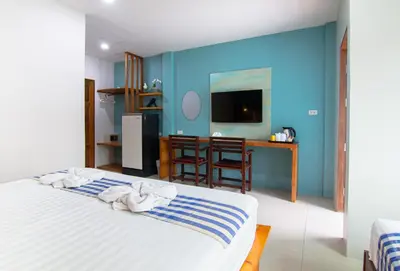 a bedroom with a bed and a blue wall at Kamala Beach Residence in Kamala Beach