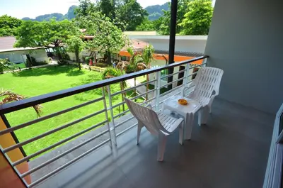 a balcony with two chairs and a table at Phi Phi Rimlay Resort in Phi Phi Don