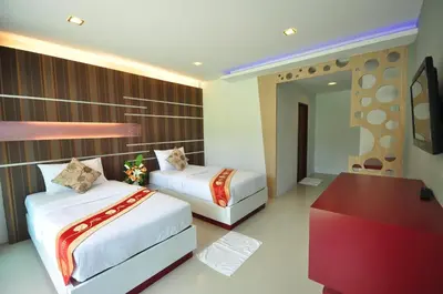 a bedroom with two beds and a desk and a mirror at Phi Phi Rimlay Resort in Phi Phi Don