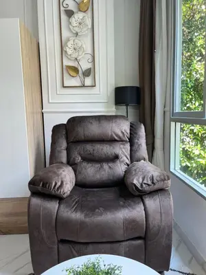 a brown leather chair sitting in a living room at Cozy and delightful room with pool view in Kathu