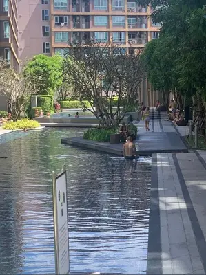 a river in a city with people sitting in the water at Cozy and delightful room with pool view in Kathu