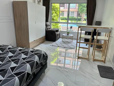 a bedroom with a bed and a living room at Cozy and delightful room with pool view in Kathu
