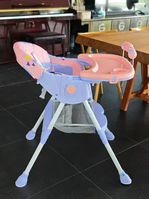 a pink and blue childs high chair next to a table at Luxury Beachfront AMANA Villa 4 Br at Ta-Ke Residence A in Phuket Town