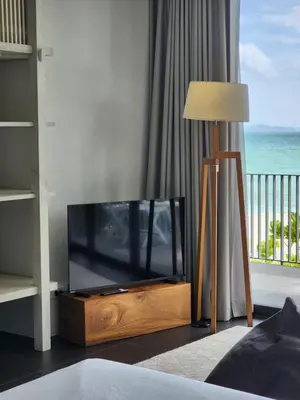 a flat screen tv sitting in a room with a window at Luxury Beachfront AMANA Villa 4 Br at Ta-Ke Residence A in Phuket Town