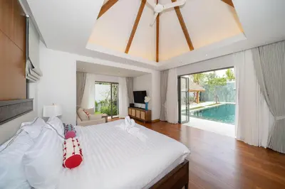 a bedroom with a white bed and a swimming pool at Spacious Mansion 4BR Villa Anchan V20 with 15m Private Pool in Gated Residence in Bang Tao Beach
