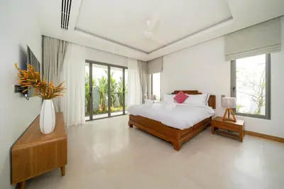 a bedroom with a bed and a vase of flowers at Spacious Mansion 4BR Villa Anchan V20 with 15m Private Pool in Gated Residence in Bang Tao Beach