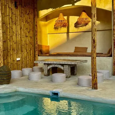 a room with a table and a swimming pool at L’Oasis Nanai in Patong Beach