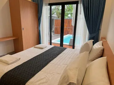 a bedroom with a bed with a view of a pool at Luxury Boutique Pool Villa Ao Nang Krabi in Ao Nam Mao