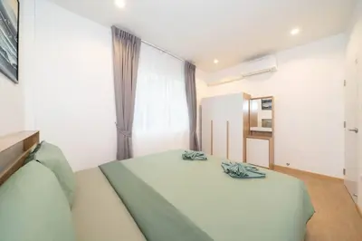 a bedroom with a large white bed and a window at 2BR townhome 300M walk to kata beach Fully equipped in Kata Beach