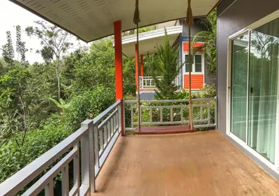 an empty porch of a house with a glass door at Bangnu Greenery Resort in Takua Thung