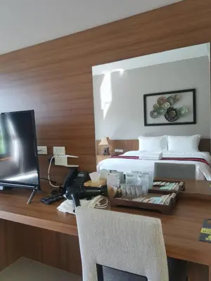 a bedroom with a bed and a desk with a computer at Bangnu Greenery Resort in Takua Thung