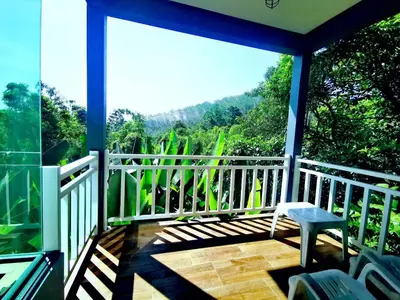 a screened in porch with a view of the mountains at Bangnu Greenery Resort in Takua Thung